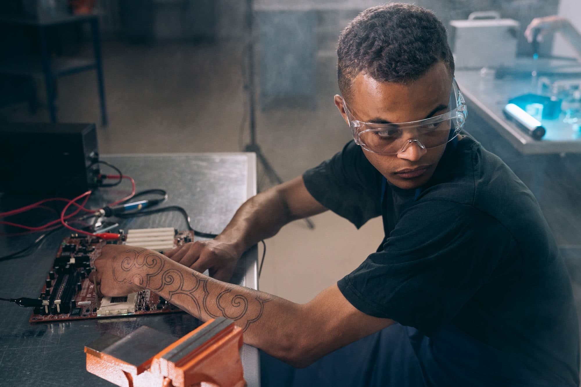 Technicien réparant une carte électronique en atelier