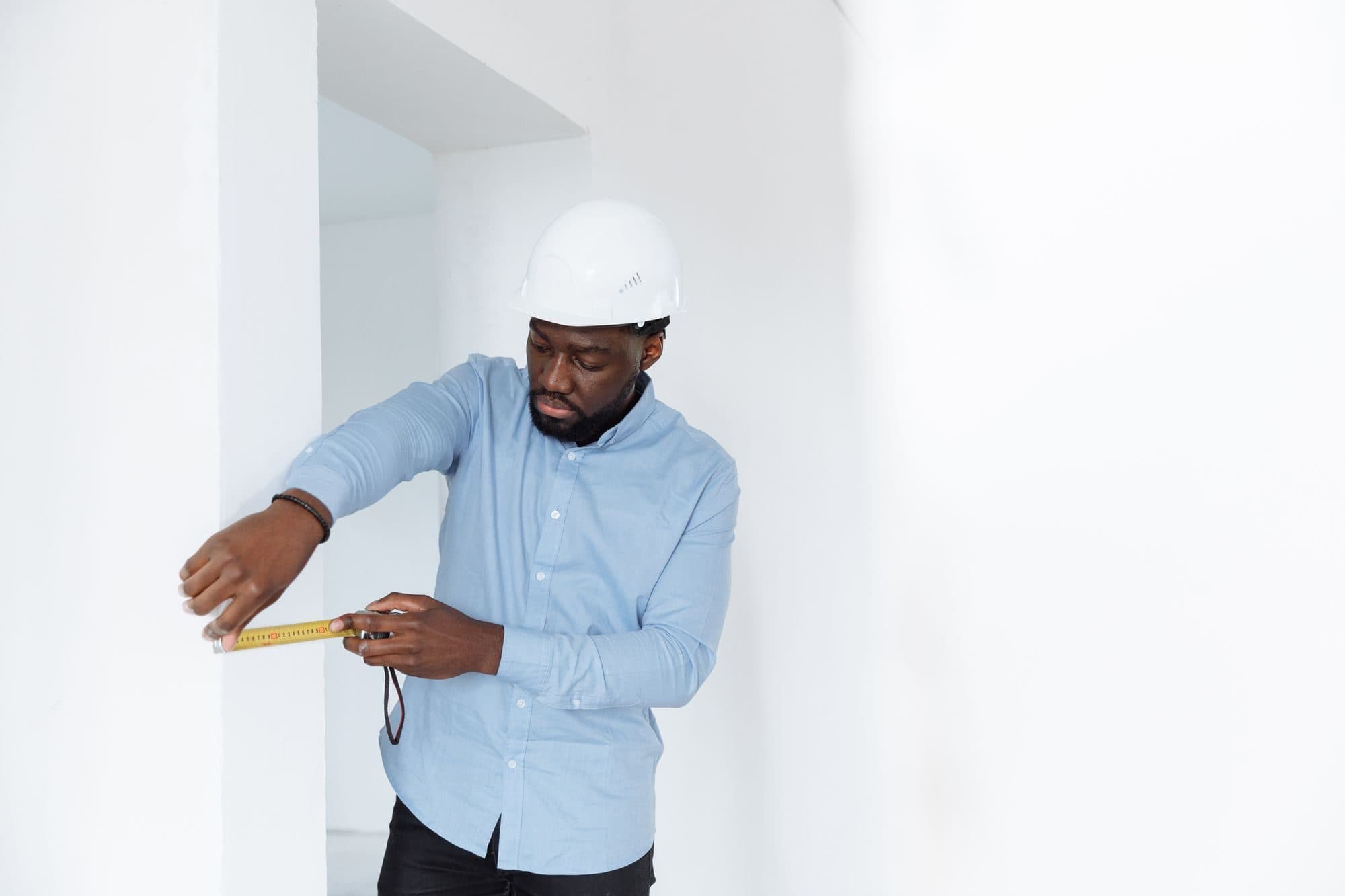 Technicien prenant des mesures dans une pièce avant une installation